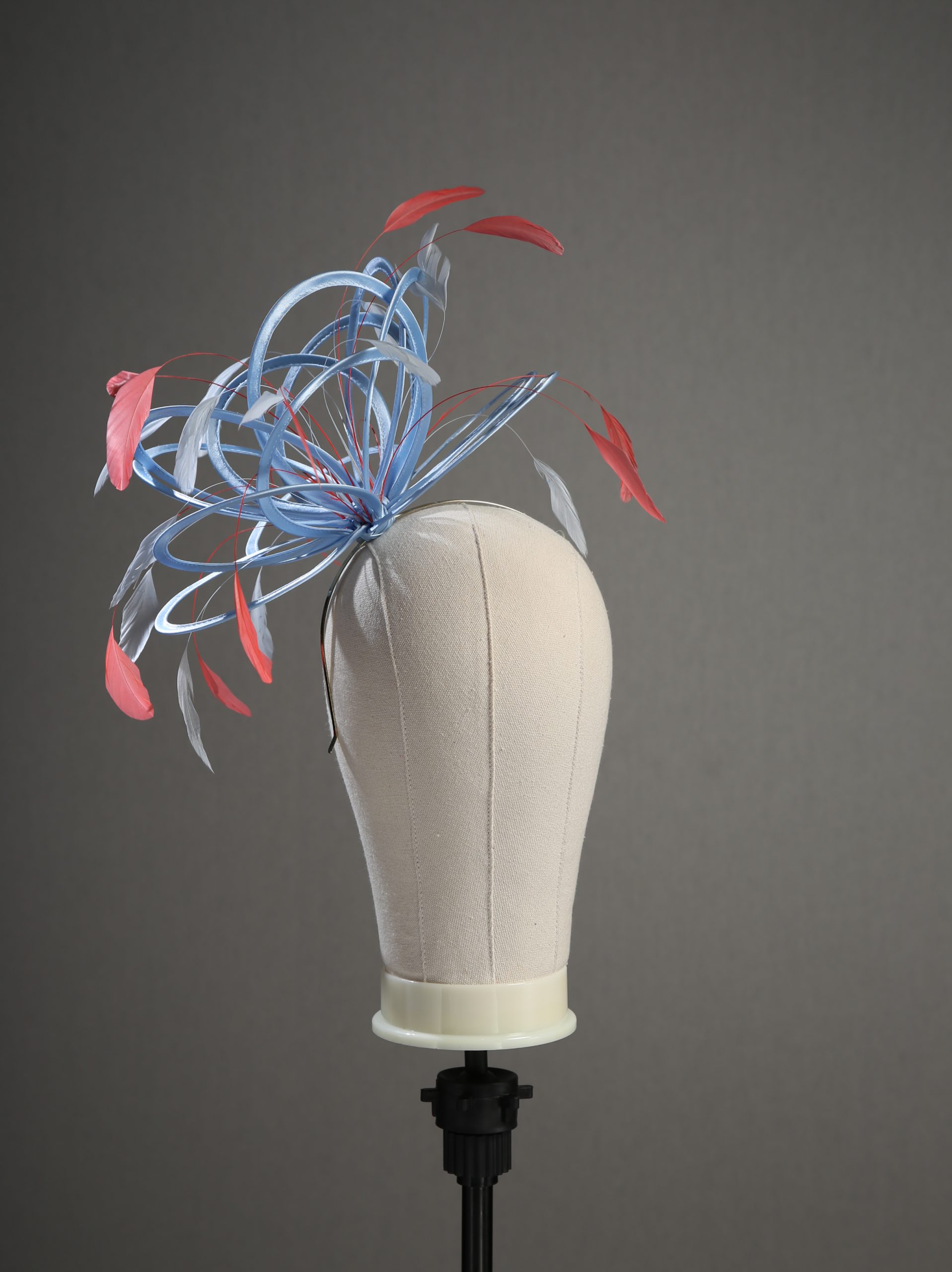 cornflower blue and coral pink medium no hackle fascinator hat (10) Ladies' formal Cornflower Blue and Coral Pink medium feather and satin loop fascinator hat. Suitable for a wedding or ladies' day at the races
