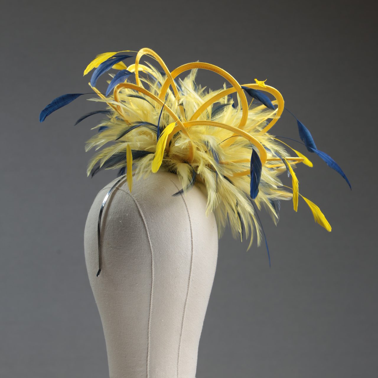 Ladies formal yellow and navy blue medium feather and satin loop fascinator hat. Suitable for a wedding or ladies day at the races