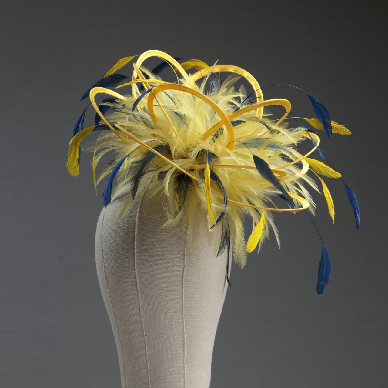 Ladies formal yellow and navy blue medium feather and satin loop fascinator hat. Suitable for a wedding or ladies day at the races