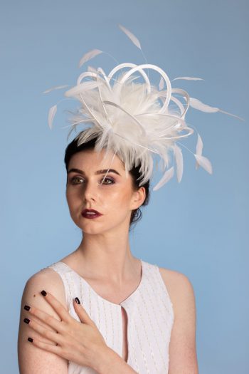 white satin loop and feather fascinator hat set on a headband